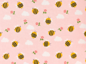 Decorative pink fabric pattern with yellow and black bees, white clouds, and small pink flowers.