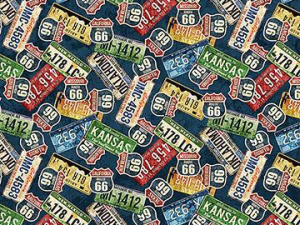 Colorful fabric pattern of overlapping vintage US highway shields (Route 66, Kansas, etc.) in red, blue, green, and yellow.